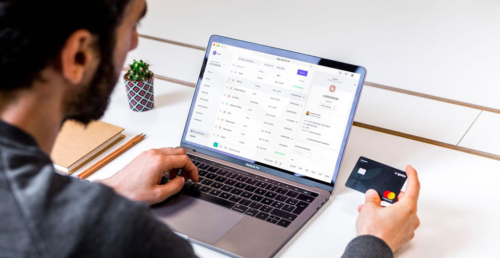 Carte bancaire professionnelle posée sur des relevés de compte montrant les frais de tenue de compte mensuels